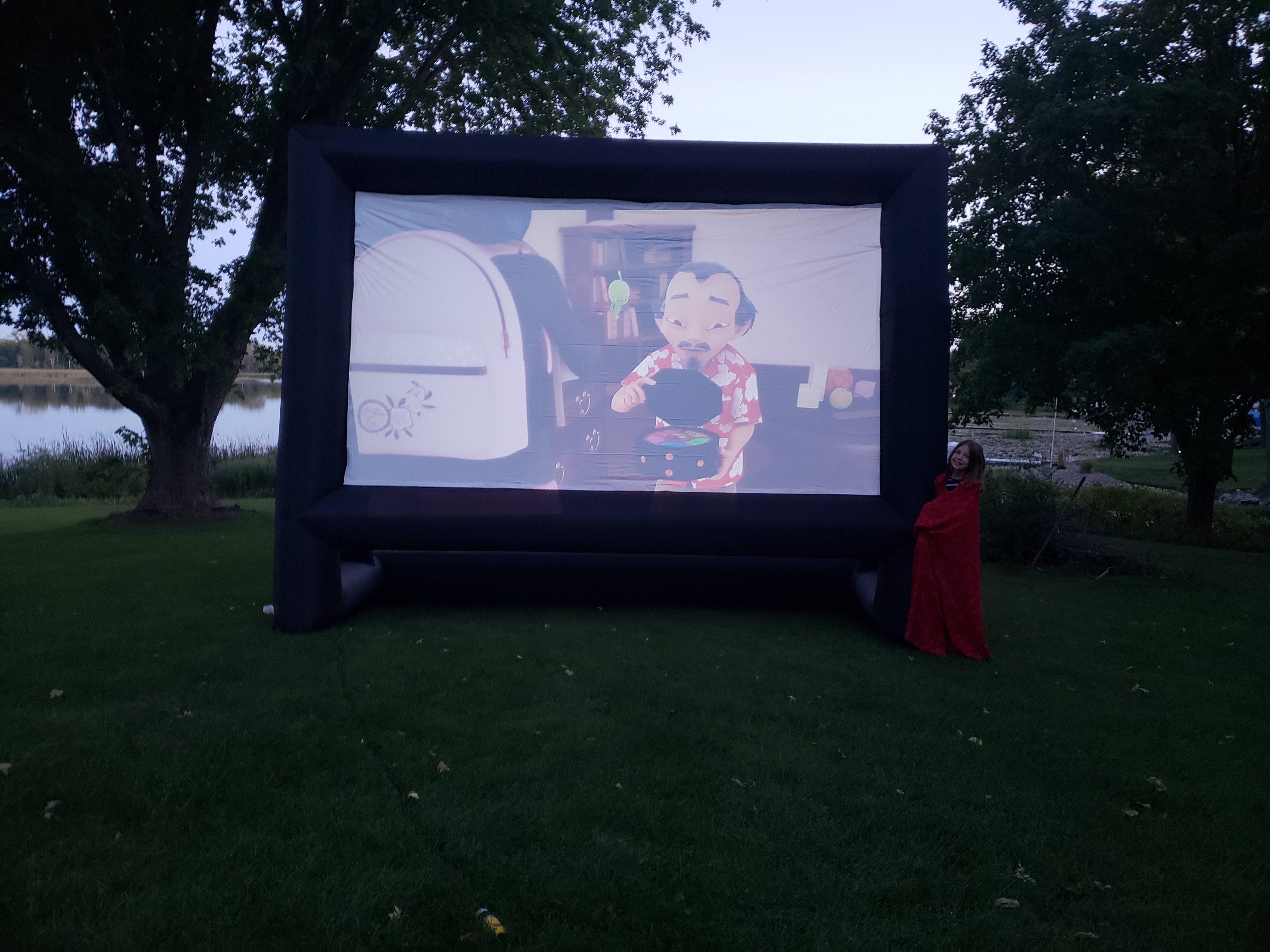 Our daughter Lily standing by the blow-up screen during our test-run at the lake this past Sunday.